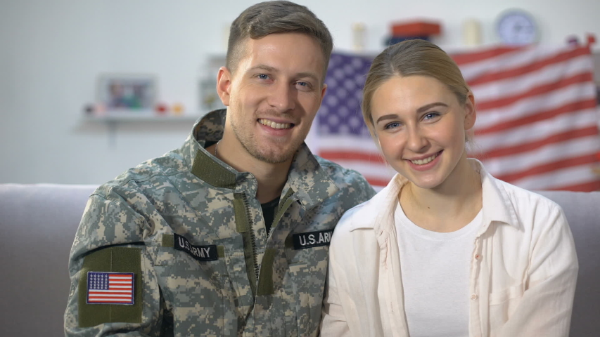Cheerful US soldier and wife showing apartment keys, military service reward