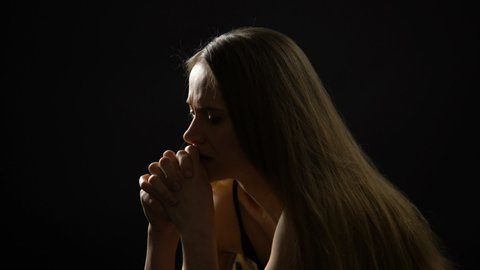 Lonely scared woman isolated on dark background, kidnapping victim, crime