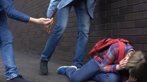 Cruel teenagers punching boy and making video on smartphone, cyberbullying