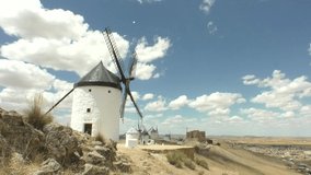Time lapse windmill at Consuegra Spain, rolling puffy cloud are moving, white lightnes clouds time lapse. Timelapse of white clouds with blue sky video loop