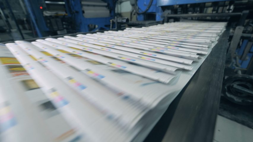 Printed magazines are moving along the transporter. Printing newspapers in typography. Royalty-Free Stock Footage #1032189185