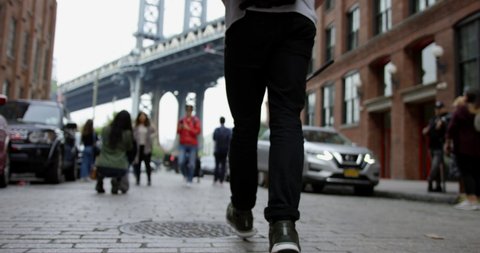 Cultured Man Walking In The Trendy Streets Of Dumbo Brooklyn Towards The Impressive Manhattan Bridge In Iconic New York City