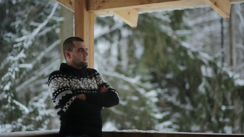 Young family stands on the porch in the winter and tea drinkers/snowfall	