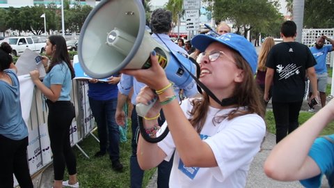Miami, Florida/USA - June 27, 2019: Joe Biden supporters standing outside. Democratic Debates 2019 Second Round. Against Donald Trump politics. Protestors with megaphone speaker.