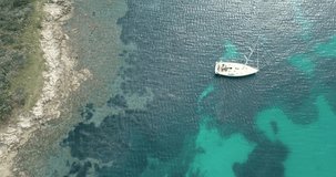 NATURE 4K Aerial drone shot revealing coastal area with a white sail boat anchored