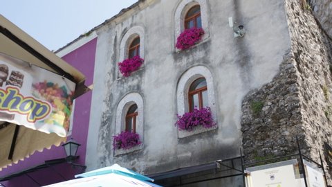 Mostar, Bosnia - June 19, 2019: Old building with pink flowers on the window sills in the ancient Ottoman Empire town of Mostar in Bosnia and Herzegovina. 