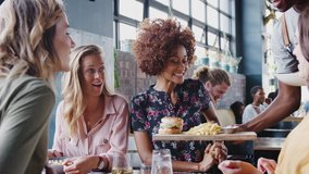 Four Female Friends Take Photos Of Food In Restaurant To Post On Social Media As Waiter Serves Meals - Powered by Shutterstock - Get 15% off with code: PIKWIZARD15