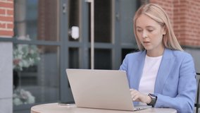 Online Video Chat on Laptop by Young Businesswoman Sitting Outdoor
