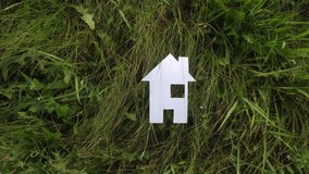 happy family construction house concept. lifestyle paper house stands in the green grass in nature. life symbol ecology video