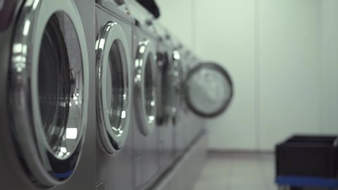 Row of working washing machines in a Laundry. Slow motion medium shot. gimbal shot