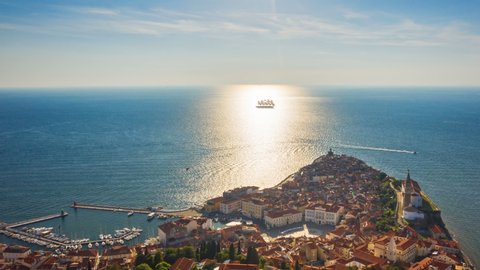 4K. Flight over old city Piran and beautiful sailing ship with five masts. Time Lapse video at sunset time. Slovenia, Europe.