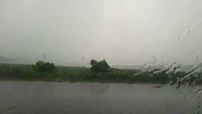 Heavy hail rain on spring day trough car window - slow motion