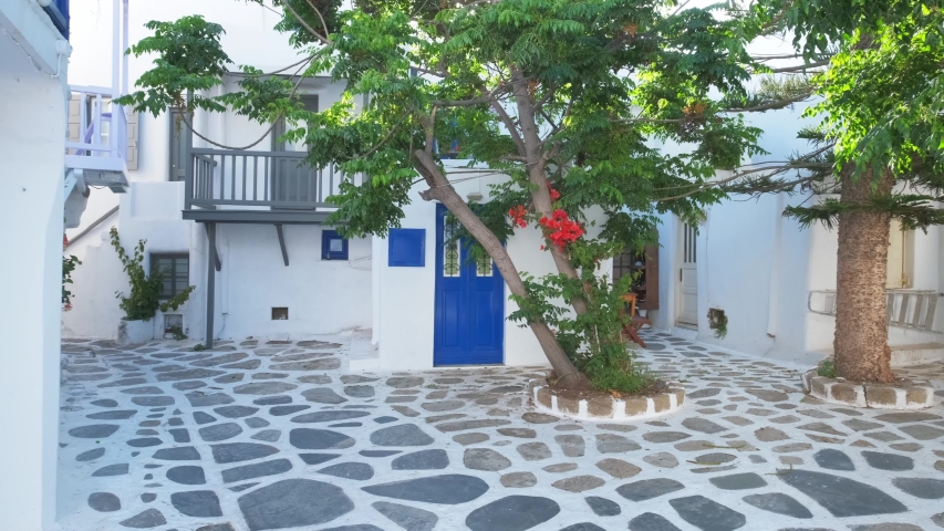 Picturesque scenic narrow streets with traditional whitewashed houses with blue doors windows of Mykonos town in famous tourist attraction Mykonos island, Greece. Horizontal camera pan
