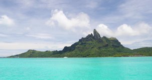 Mount Otemanu, Bora Bora, Tahiti, French Polynesia with yacht, coral lagoon sea and Mt Pahia, Mt Otemanu, Tahiti, south Pacific Ocean. 4K, 59.94 FPS slow motion.