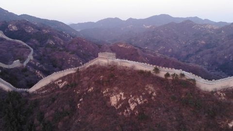 Great Wall at Badaling, aerial shot in evening twilight. Embattled fortification lies over hill, small watch tower at top point. Famous Wonder of World located at China