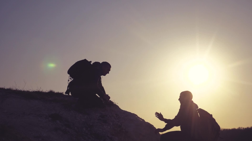 teamwork help business travel silhouette concept. group of tourists lends a helping hand climb lifestyle the cliffs mountains. people climbers climb to the top overcoming hardships the path to victory Royalty-Free Stock Footage #1032243275