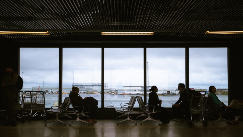 Time lapse of people walking in the international airport at the departure gate. The crowd are passengers and flight crews waiting on seat chair for airplane to take off. Royalty-Free Stock Footage #1032247658