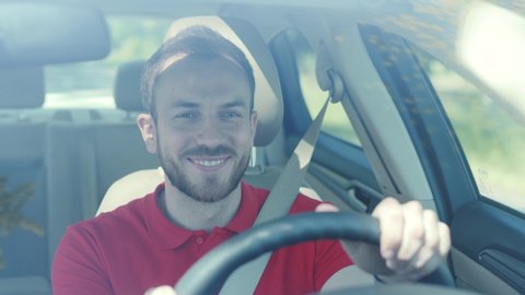 Happy young smiling man driving a car on a road trip sunset sunlight transport holiday happy adventure car short hair free time journey smiling summer travel slow motion