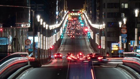 Gorgeous view of a modern highway with lights and rushing autos and buses in Brussels at night in spring in timelapse. 