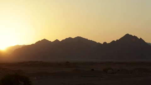 The road in the desert, the view of the mountains from the window of a moving car. Sunset in the desert. Fast motion. Road trip. Egypt