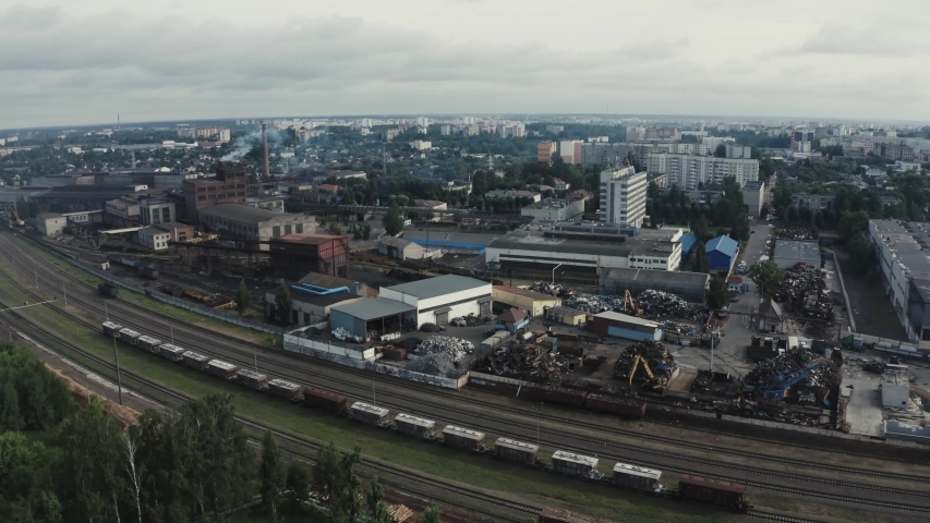 Flying above industrial railroad station with cargo trains and freight containers on a cloudy day.railroads and shipping container trains.