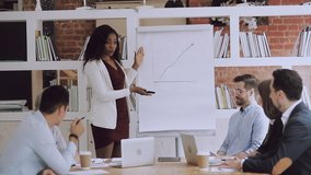 Female black manager coach explain graph to diverse employees group give flip chart presentation at office meeting, african business woman speaker teaching team at corporate training in boardroom - Powered by Shutterstock - Get 15% off with code: PIKWIZARD15