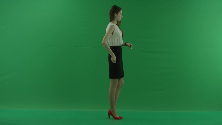 a thoughtful woman is waiting and loking at her whatch . She wears formal dress: white shirt and blak skirt. Businesswoman think, got idea over green screen