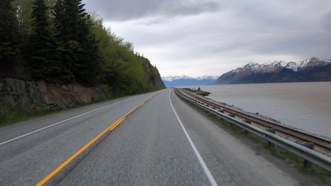 POV Driving through the Chugach State Park; driving south on the National Forest Scenic Byway (also known as the Seward Highway) along Turnagain Arm of Cook Inlet; view of the Chugach Mountains