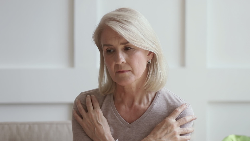 Worried thoughtful middle aged lady looking away sit alone at home feeling anxious lonely, sad pensive melancholic older mature woman suffer from sorrow or grief, thinking of health problem solitude  Royalty-Free Stock Footage #1032303743