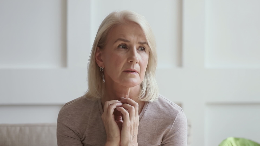 Worried thoughtful middle aged lady looking away sit alone at home feeling anxious lonely, sad pensive melancholic older mature woman suffer from sorrow or grief, thinking of health problem solitude  Royalty-Free Stock Footage #1032303743