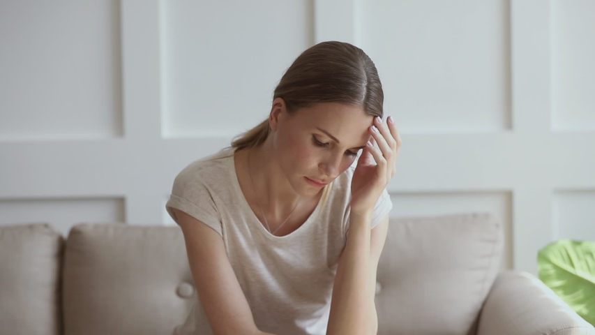 Worried insecure young lady thinking of problem sitting alone at home thoughtful depressed woman feeling concerned doubtful making difficult decision troubled with anxiety, doubt or unwanted pregnancy Royalty-Free Stock Footage #1032303761