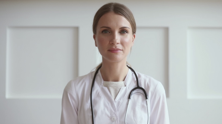 Young professional woman doctor wear uniform with stethoscope talk by conference video call chat consult patient online looking at camera webcam, distant medical consultation in internet app concept Royalty-Free Stock Footage #1032303773