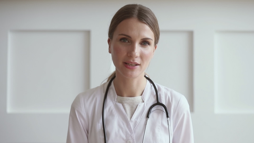 Young professional woman doctor wear uniform with stethoscope talk by conference video call chat consult patient online looking at camera webcam, distant medical consultation in internet app concept Royalty-Free Stock Footage #1032303773