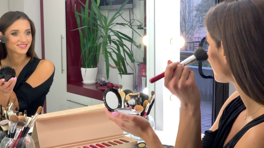 Beautiful woman making professional makeup in beauty studio | Shutterstock HD Video #1032309200