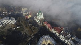 Aerial view of St. Andrew Church early in the morning in dense fog in autumn, Kiev, Ukraine. 4k video