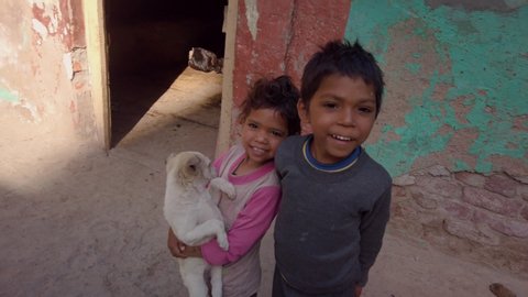 Indian boy and girl playing on the street with a puppy, India, Vrindavan: 01.02.2019