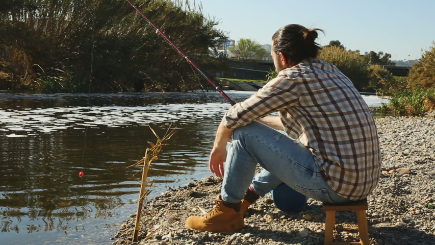 Bearded fisherman fishing on weekend in the river