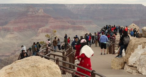 Grand Canyon, Arizona - April 15, 2019: Tourists crowd an overlook on Mather Point tourist stop in the South Rim of the Grand Canyon National Park.