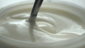 macro - video shooting,Slow motion of mixing yogurt with spoon in the cup