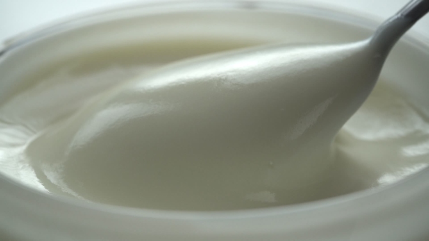 macro - video shooting,Slow motion of mixing yogurt with spoon in the cup Royalty-Free Stock Footage #1032346025