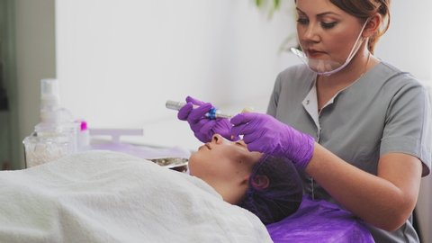 Young woman is lying in beauty salon during procedure of bb glow treatment for face, close-up
