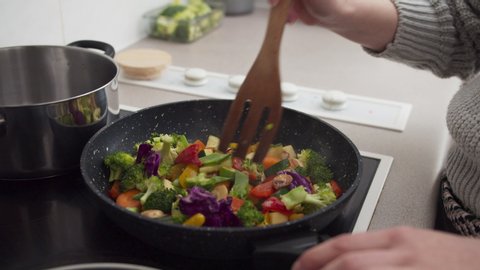 Woman hands cooking vegetables on frying pan in the kitchen. Healthy delicious food diet and meal plan for weight loss
Close up shot