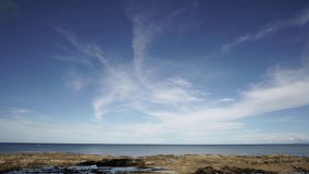 Nature scenery at beach with clouds and blue sky. Cinematic color graded footage. 