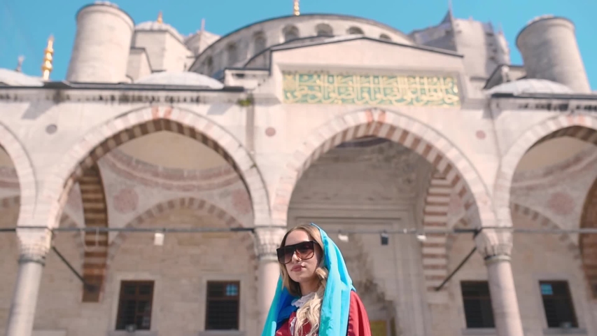 Slow Motion: Attractive beautiful girl in shirt poses in front of Sultan Ahmet Mosque in Istanbul,Turkey.Travel Concept