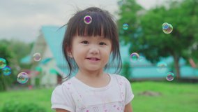 Asian little girl is playing bubbles at the backyard. She having fun while running and catching up bubbles. Slow motion. Record in 120 fps. - Powered by Shutterstock - Get 15% off with code: PIKWIZARD15