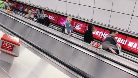 LONDON - JUNE 26, 2019: People on escalator stairs in modern city tunnel on London Underground crossrail tube train station
