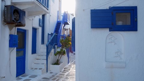 Walking with steadycam steadicam in picturesque scenic narrow streets with traditional whitewashed houses with blue doors windows of Mykonos town in famous tourist attraction Mykonos island, Greece
