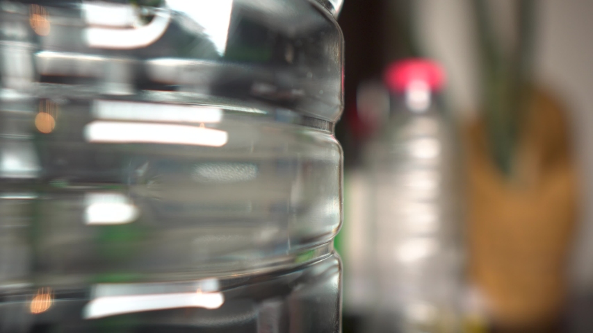 Plastic Drinking water bottle on table with empty plastic bottles rack focus waste recycle home lifestyle Royalty-Free Stock Footage #1032389375