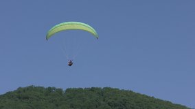 Paragliding over mountains to the valley 4K video