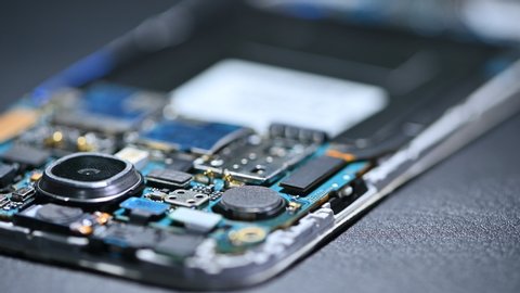 The movement footage of the inside of the smartphone's motherboard lay on the back table. the concept of computer hardware, mobile phone, electronic, repairing, upgrade and technology.